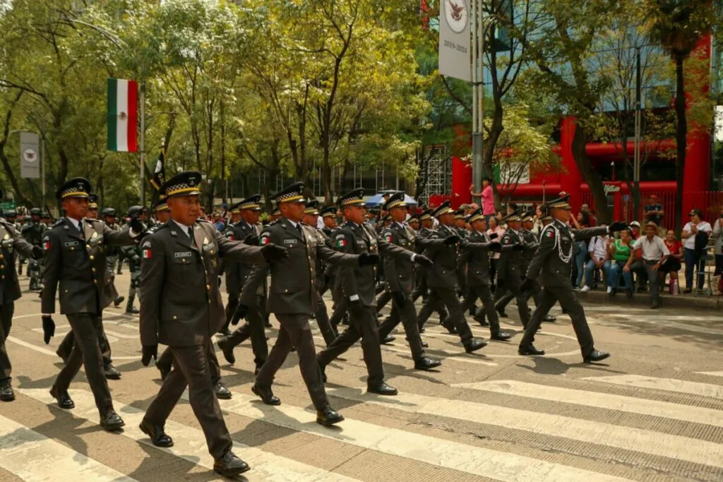 Desfile militar en México recorriendo avenidas emblemáticas con fuerzas armadas y ciudadanía celebrando la independencia.