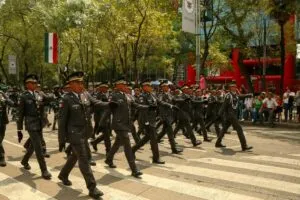 Desfile militar en México recorriendo avenidas emblemáticas con fuerzas armadas y ciudadanía celebrando la independencia.