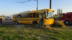 Accidente escolar en Fowler, California, con autobús detenido y presencia de emergencia tras choque con camión de servicios.