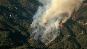 Bomberos extinguiendo incendio forestal en North County, California, mientras levantan alertas de evacuación