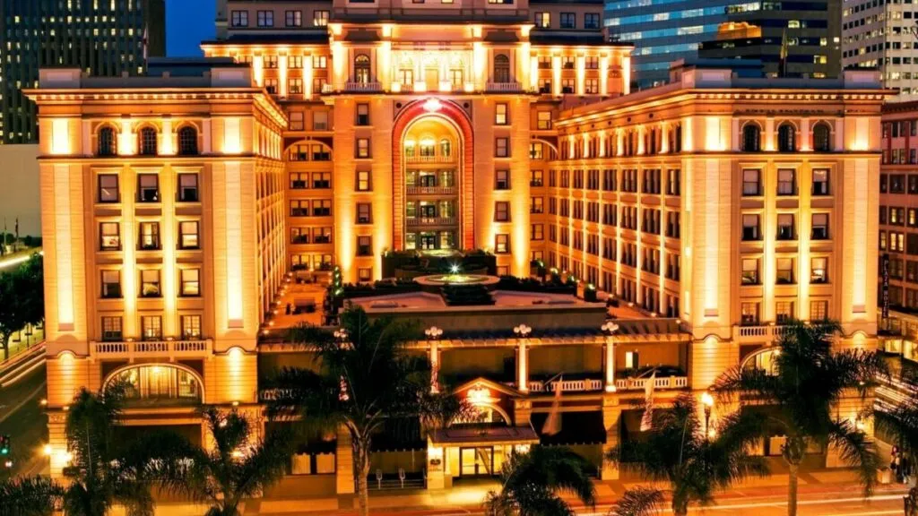 Vista nocturna del U.S. Grant Hotel en el centro de San Diego, iluminado y rodeado de vida urbana, reflejando su historia y elegancia centenaria.