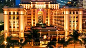 Vista nocturna del U.S. Grant Hotel en el centro de San Diego, iluminado y rodeado de vida urbana, reflejando su historia y elegancia centenaria.