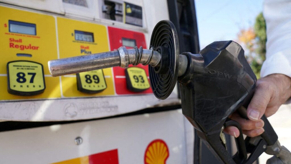 Conductores cargan combustible en una gasolinera de San Diego mientras el precio por galón registra su mayor aumento del año.