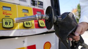 Conductores cargan combustible en una gasolinera de San Diego mientras el precio por galón registra su mayor aumento del año.