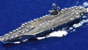 Helicóptero naval MH-60R Sea Hawk volando sobre el océano frente al USS Nimitz