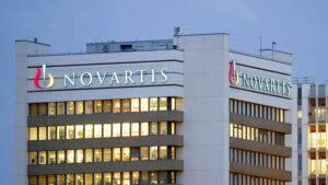 Fachada moderna de un edificio biotecnológico en San Diego con el logo de Novartis, simbolizando la compra de Avidity Biosciences