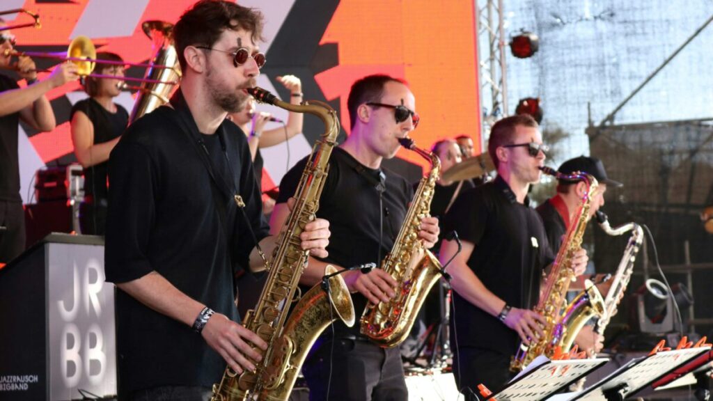Escenario iluminado del San Diego-Tijuana Jazz Festival con músicos en vivo y público disfrutando de un ambiente cultural binacional