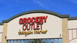 Fachada moderna de una tienda Grocery Outlet en Pacific Beach, San Diego, con letreros de apertura y compradores locales en la entrada.