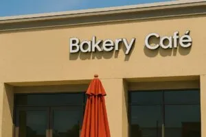 Fachada real de panadería asiática Sheng Hui Dim Sum en San Diego con letrero de cierre y sombrilla roja bajo luz solar