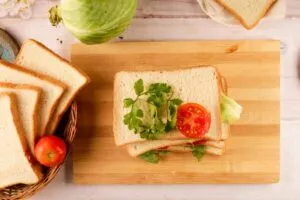 Diferentes tipos de sándwiches con ingredientes latinos en una mesa de madera en San Diego