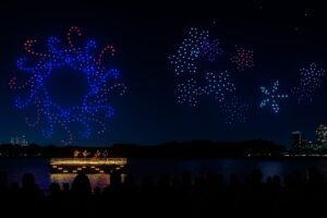 Cielo nocturno de San Diego iluminado por drones durante el espectáculo DroneArt, evento gratuito con música y tecnología.