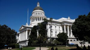 Edificio del Capitolio de California con billetes y documentos presupuestales en primer plano, simbolizando el gasto político.
