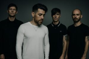 Miembros de la banda AFI posando con estilo oscuro, representando el concierto en San Diego