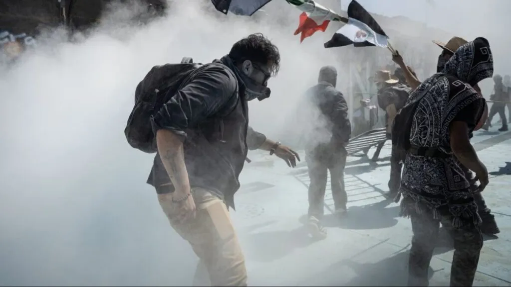 Multitud mexicana avanzando en protesta pacífica con carteles y ambiente de unidad intergeneracional