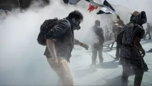 Multitud mexicana avanzando en protesta pacífica con carteles y ambiente de unidad intergeneracional