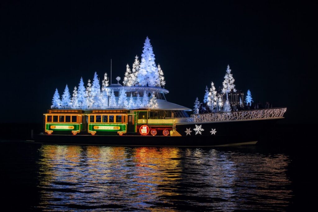 Embarcaciones iluminadas navegando en la bahía de San Diego durante el desfile de barcos navideños