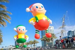 Globos gigantes desfilando frente a la bahía de San Diego durante el Holiday Bowl Parade