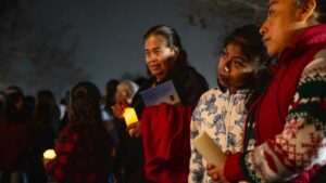 Familias de latinos participan en una posada navideña con vigilancia comunitaria en San Marcos