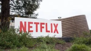 Ilustración editorial de Netflix y Warner Bros fusionando operaciones en un entorno que refleja transformación global del contenido.