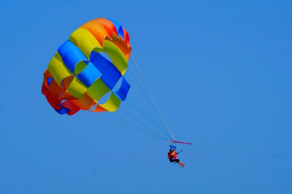 Persona practicando parapente en San Diego con vista al océano desde los acantilados de La Jolla