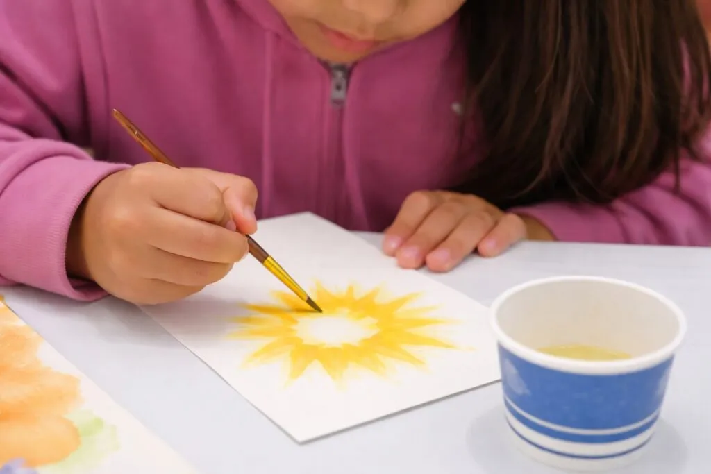 Niños hispanos leyendo y dibujando en biblioteca pública de San Diego durante el Winter Reading Challenge