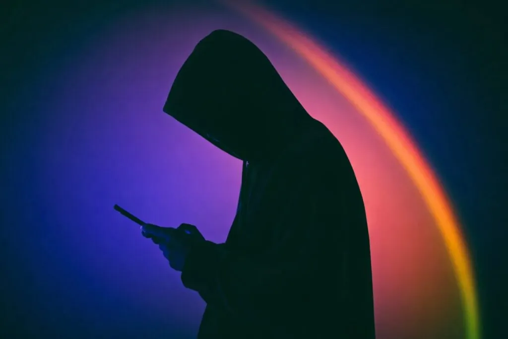 Persona encapuchada usando celular, representa el aumento de la extorsión en México