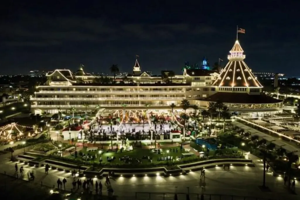Vista nocturna del Hotel del Coronado en San Diego con luces cálidas y arquitectura victoriana