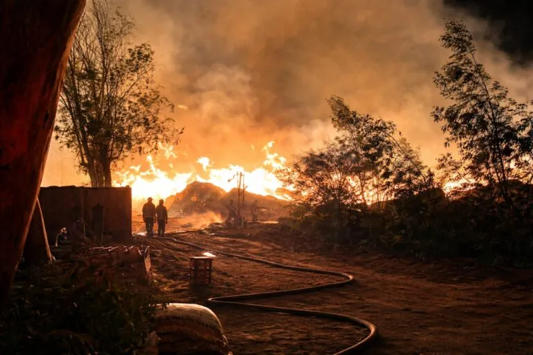 Imagen del incendio en El Refugio, Tijuana, con llamas activas y presencia de bomberos durante la evacuación