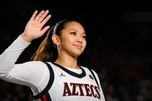 Equipo Aztecs femenil de San Diego State celebrando su título de temporada regular en la Mountain West con trofeo en la cancha
