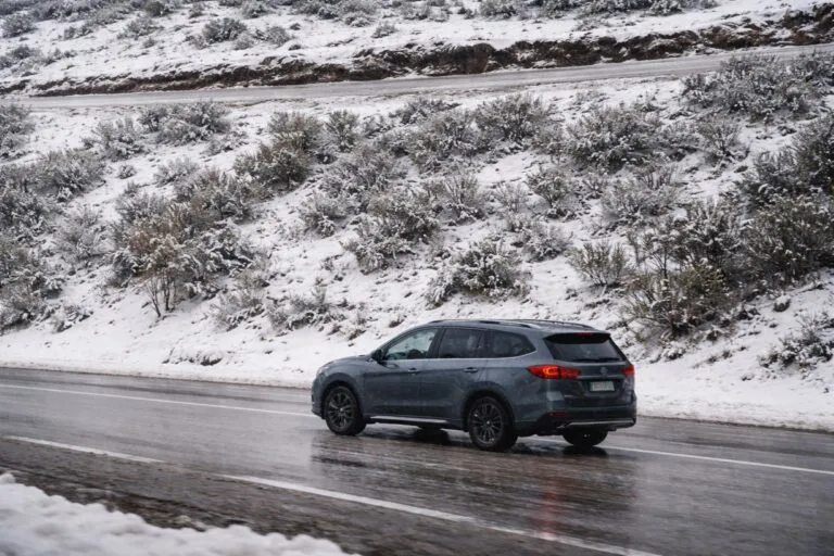 Vista panorámica de San Diego con nubes de tormenta, lluvia intensa y montañas nevadas bajo un cielo gris