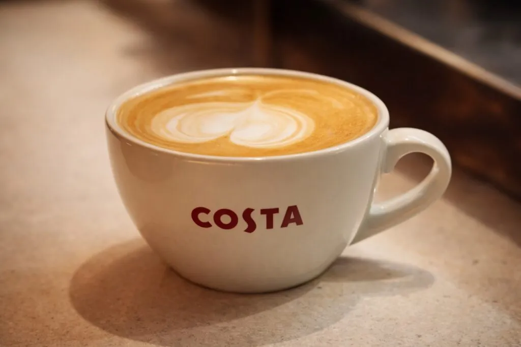 Interior moderno de una cafetería Costa Coffee México con clientes disfrutando café