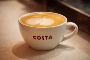 Interior moderno de una cafetería Costa Coffee México con clientes disfrutando café