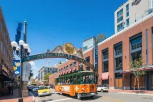 Tranvía turístico Old Town Trolley cruzando el Gaslamp Quarter en San Diego con cielo despejado y arquitectura urbana