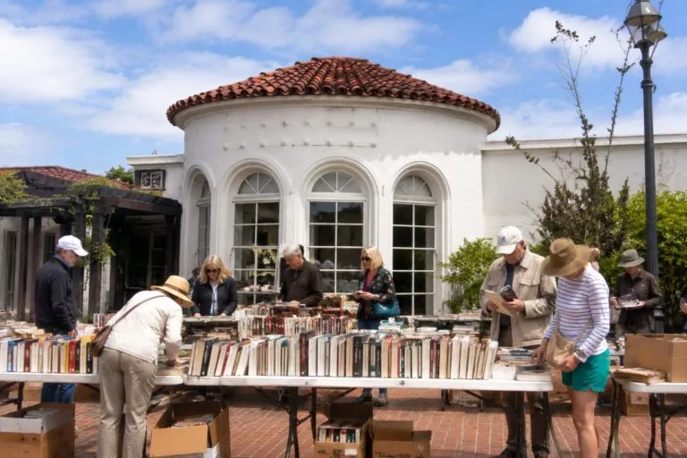 Venta de libros en La Jolla dentro del Athenaeum de San Diego con asistentes explorando ejemplares y vinilos