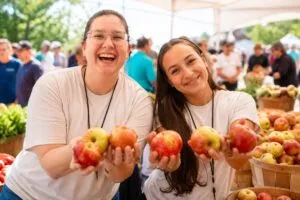Feria de la Manzana Gravenstein en California con productores locales, manzanas frescas y ambiente familiar de verano.