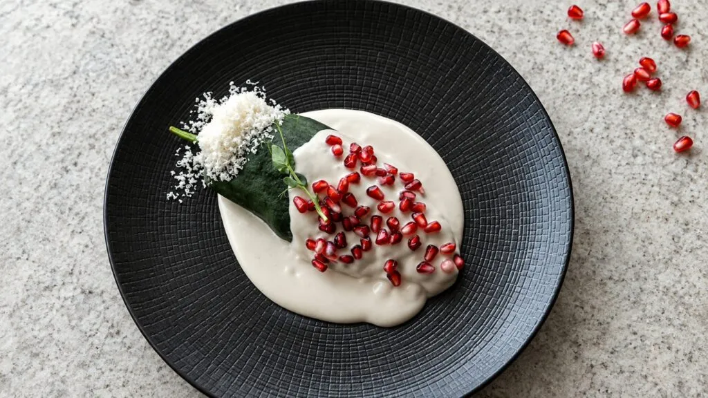 Chile en nogada elaborado con ingredientes de temporada y servido en una mesa tradicional mexicana.