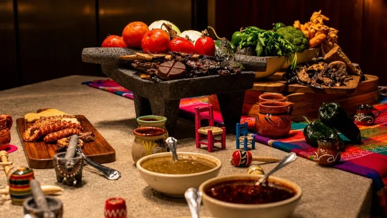 Mesa preparada para una noche mexicana con comida, música y decoración del 15 de septiembre.