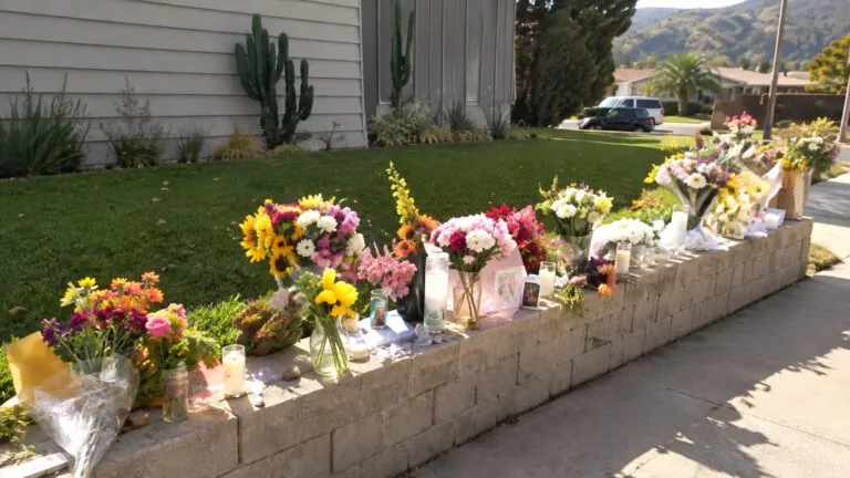 Flores y fotografías colocadas frente a una vivienda de San Carlos, San Diego, en memoria de la familia Voight.