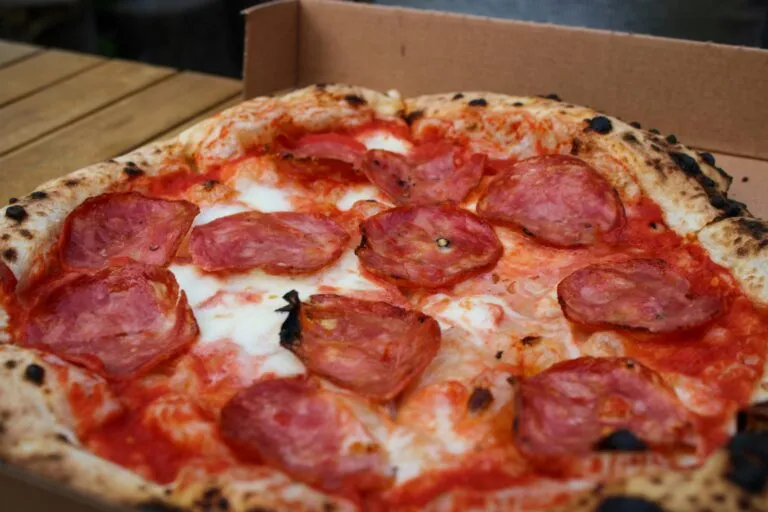 Pizza preparada para comida a domicilio junto con antojitos mexicanos y aplicaciones de entrega digital.